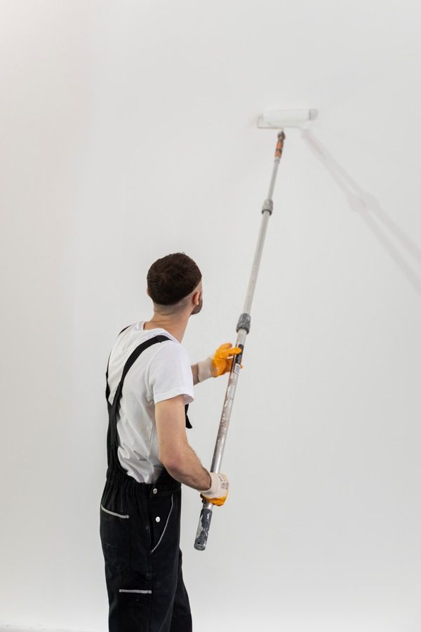 medium-shot-young-man-painting-wall_600x900